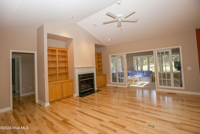 unfurnished living room with a fireplace, light wood-type flooring, ceiling fan, and lofted ceiling