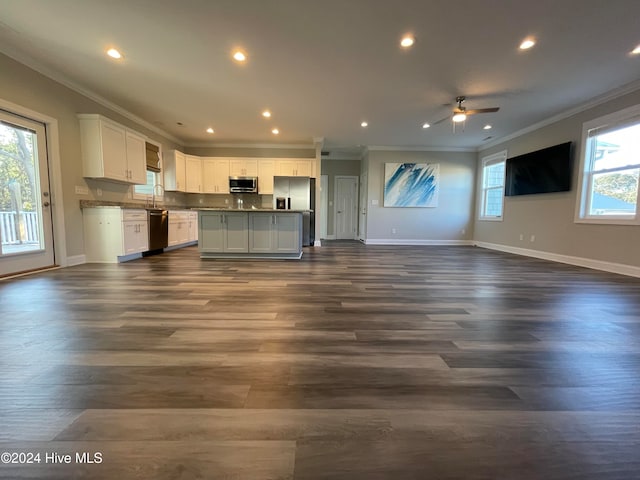 unfurnished living room featuring dark hardwood / wood-style flooring, ceiling fan, ornamental molding, and sink