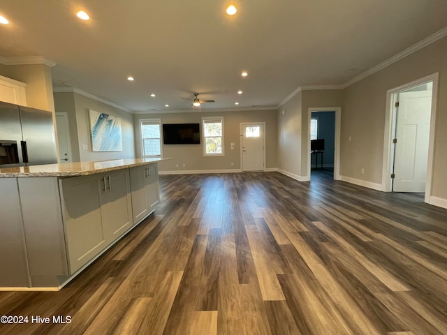 kitchen with white cabinetry, ceiling fan, light stone countertops, dark hardwood / wood-style flooring, and ornamental molding