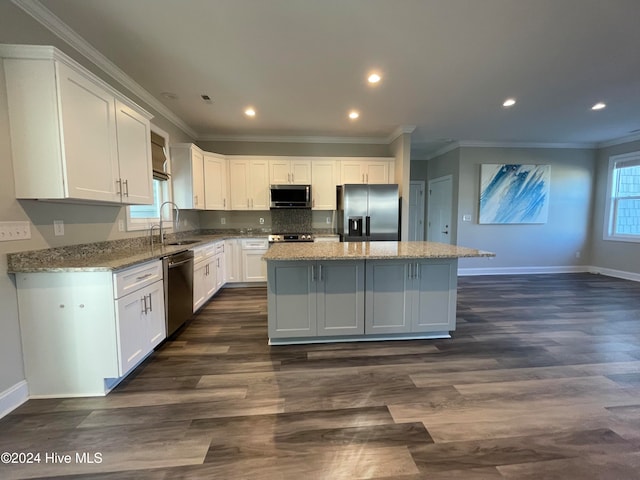 kitchen with a center island, white cabinets, stainless steel appliances, and plenty of natural light