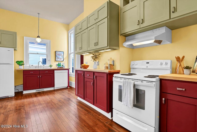 kitchen featuring pendant lighting, white appliances, sink, and dark hardwood / wood-style floors