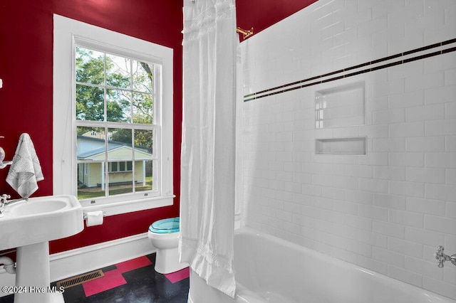 bathroom featuring toilet and shower / bath combo with shower curtain