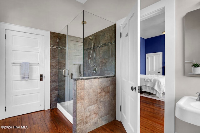 bathroom featuring hardwood / wood-style flooring and a shower with shower door