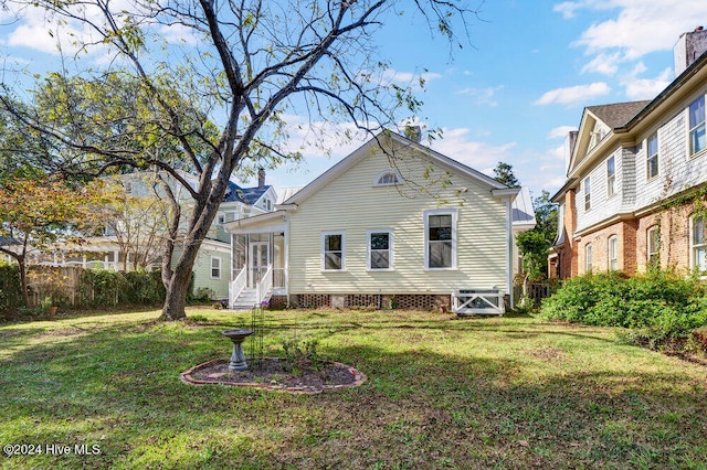 back of house with a sunroom and a yard