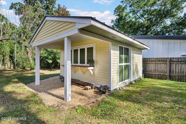 view of side of property featuring an outbuilding and a yard