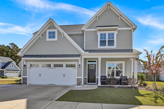 craftsman house featuring a garage, covered porch, and a front lawn