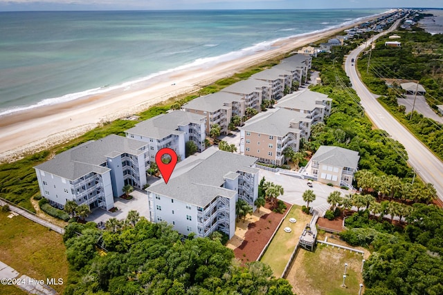 birds eye view of property featuring a beach view and a water view