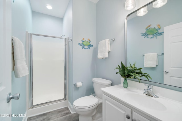 bathroom with vanity, toilet, a shower with shower door, and wood-type flooring