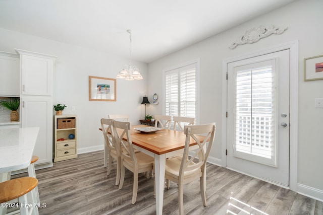 dining space with wood-type flooring and a chandelier