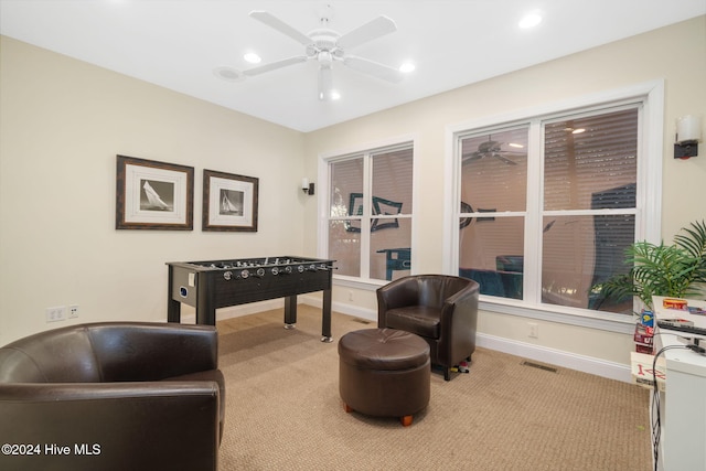 recreation room with ceiling fan and light carpet