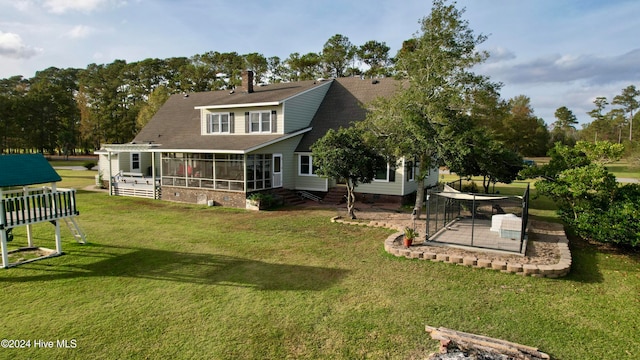 rear view of property with a patio, a sunroom, and a yard