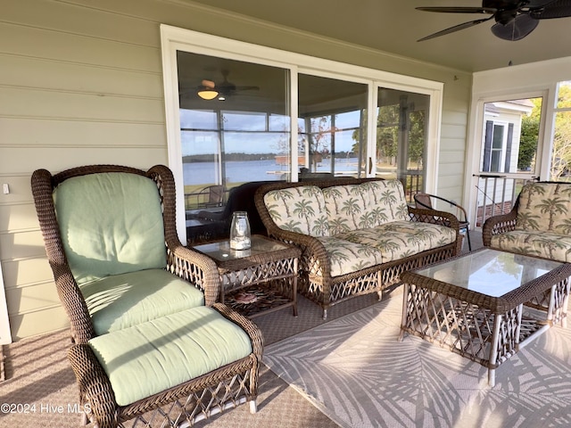 sunroom / solarium featuring a water view and ceiling fan