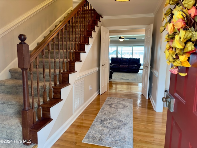 foyer with hardwood / wood-style flooring and crown molding