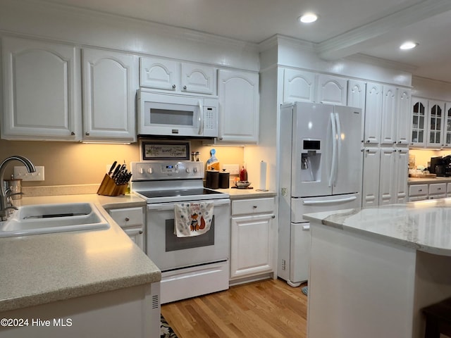 kitchen with white cabinetry, sink, and white appliances