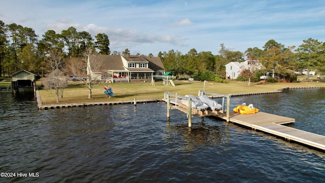 view of dock with a water view and a lawn