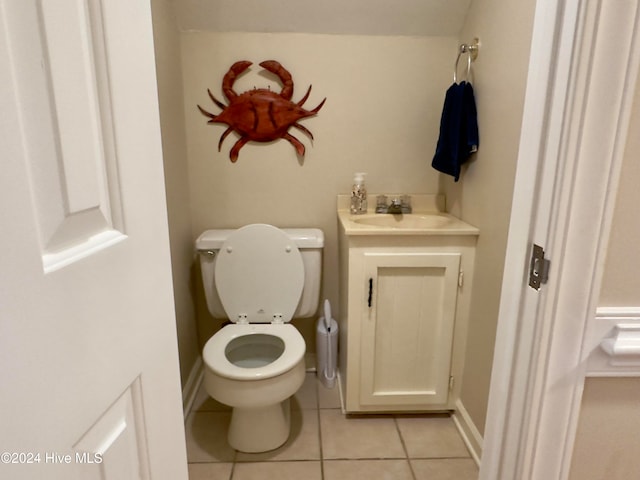 bathroom with toilet, vanity, and tile patterned flooring