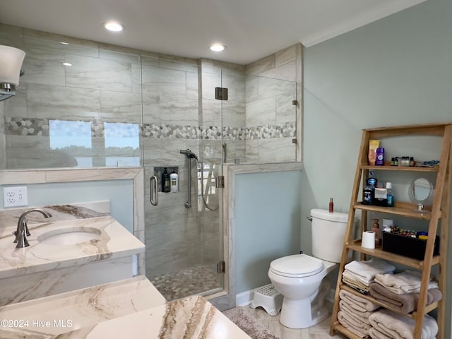 bathroom with a shower with shower door, vanity, toilet, and tile patterned floors