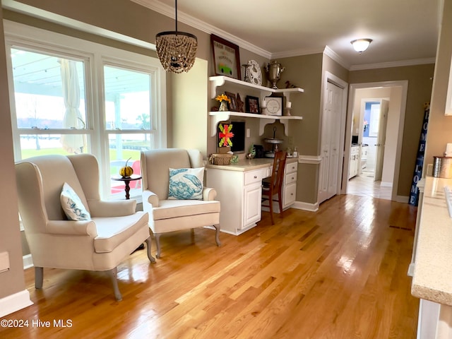 sitting room with built in desk, a chandelier, light hardwood / wood-style flooring, and ornamental molding