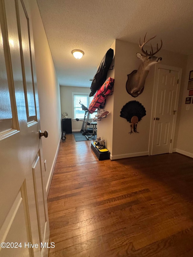 hall featuring hardwood / wood-style floors and a textured ceiling