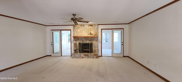 unfurnished living room featuring crown molding, light colored carpet, ceiling fan, and a fireplace