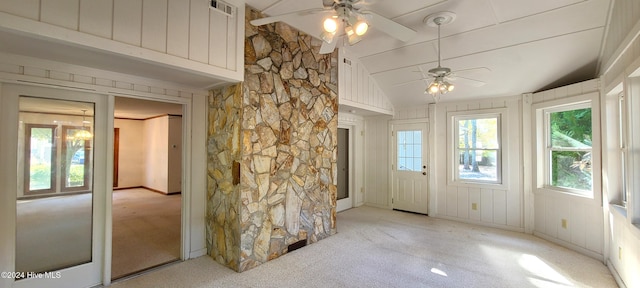 interior space featuring ceiling fan, vaulted ceiling, light carpet, and a healthy amount of sunlight