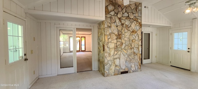 foyer featuring ceiling fan, vaulted ceiling, and light colored carpet