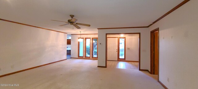 empty room with ceiling fan, light carpet, and crown molding