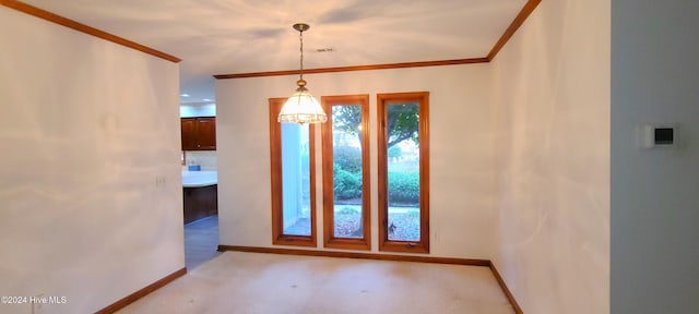 foyer entrance featuring light carpet, crown molding, and an inviting chandelier