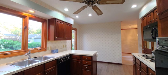 kitchen featuring black appliances, sink, kitchen peninsula, ceiling fan, and light hardwood / wood-style flooring