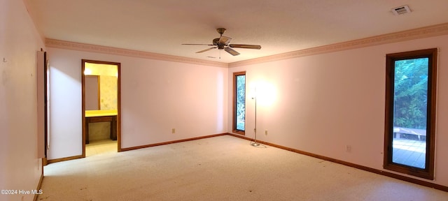 carpeted spare room featuring ceiling fan, plenty of natural light, and crown molding