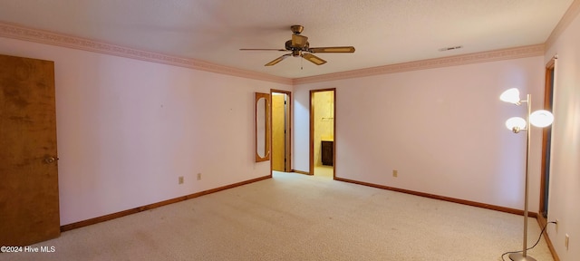 carpeted empty room featuring ceiling fan and crown molding