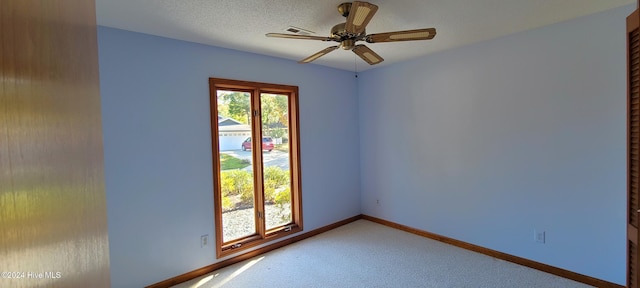 unfurnished room with a textured ceiling, carpet flooring, and ceiling fan