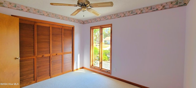 unfurnished bedroom with carpet flooring, ceiling fan, and a closet