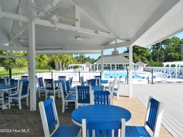 view of patio with a community pool and ceiling fan