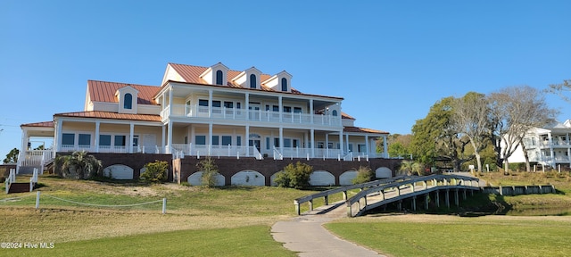 back of house with a yard and a balcony