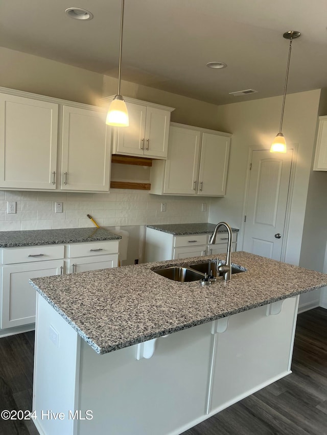 kitchen with dark hardwood / wood-style flooring, white cabinetry, sink, and hanging light fixtures