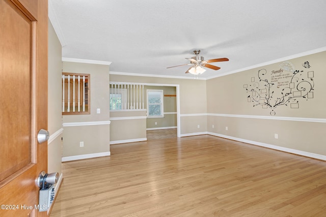 empty room with light wood-type flooring, a textured ceiling, ceiling fan, and crown molding