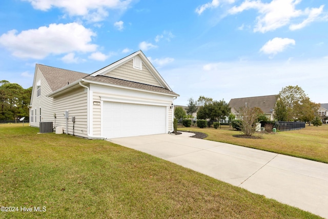 view of side of property with a garage, a lawn, and central AC