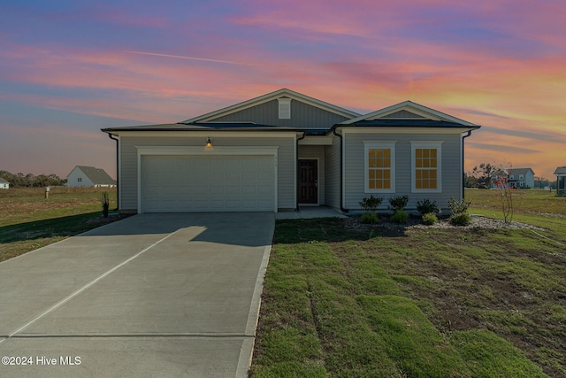 view of front of property featuring a garage and a yard