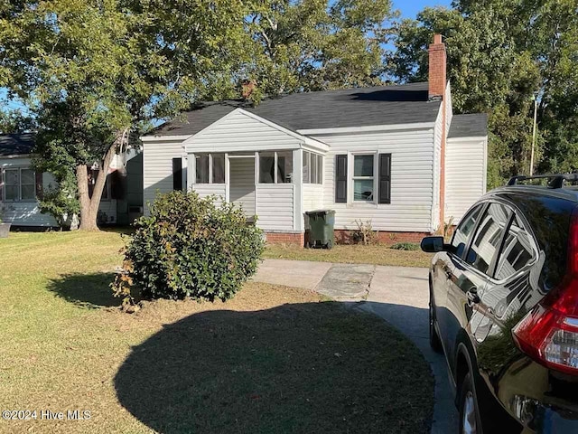 view of front of house with a front lawn and a sunroom