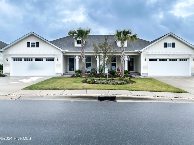 view of front of house featuring a porch, a garage, and a front yard