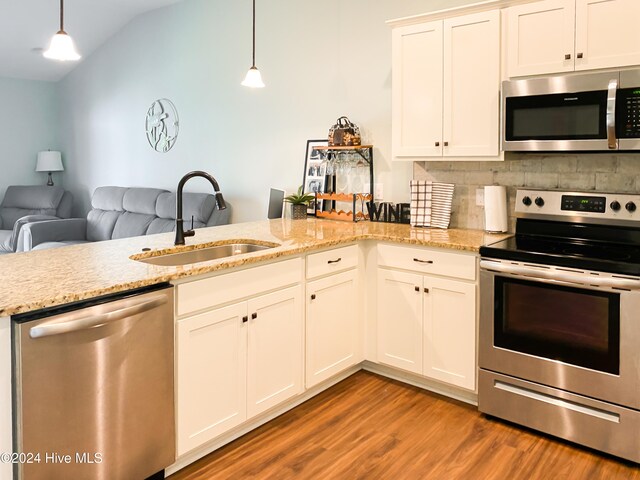 kitchen featuring white cabinetry, sink, stainless steel appliances, light hardwood / wood-style flooring, and decorative light fixtures