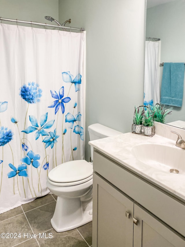 bathroom with tile patterned flooring, a shower with curtain, vanity, and toilet