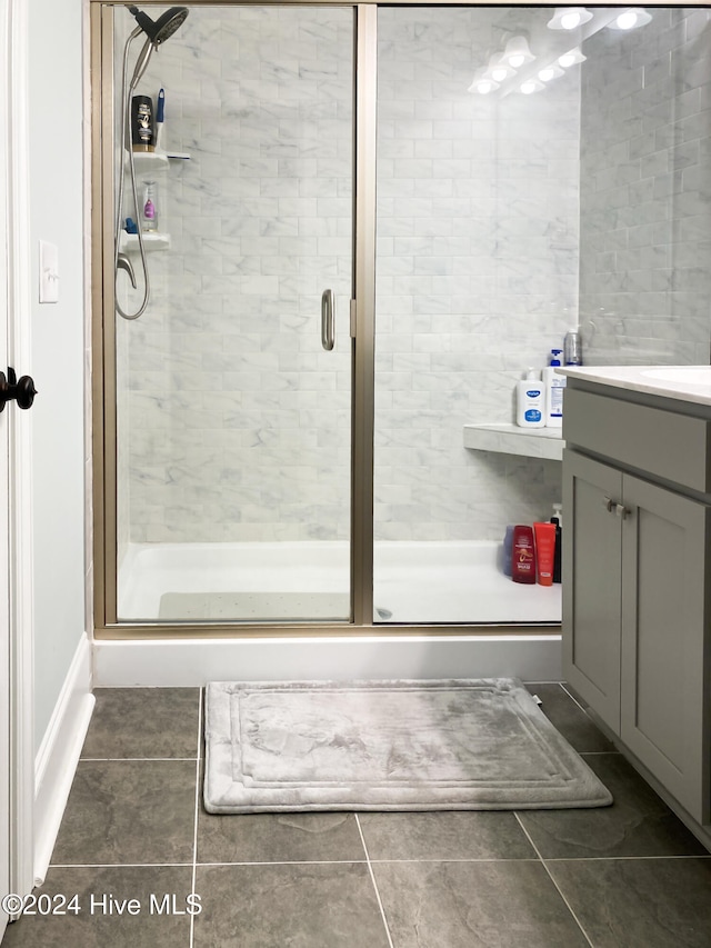 bathroom featuring tile patterned floors, vanity, and a shower with shower door