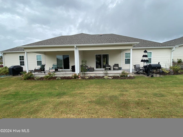 back of property with a yard and a patio area