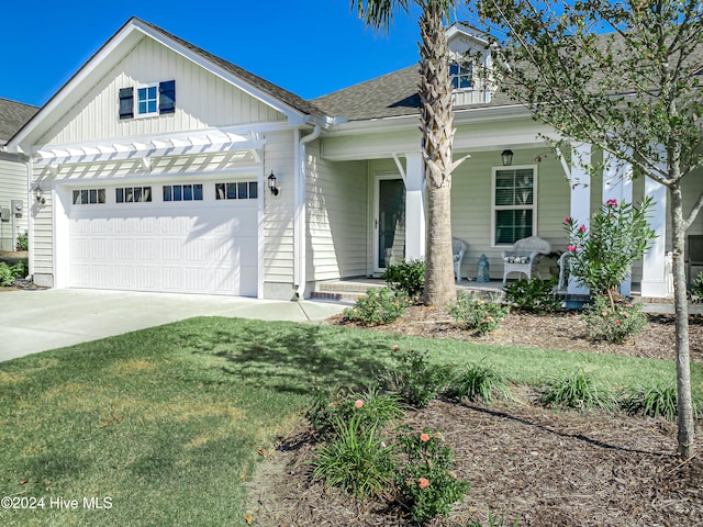 view of front of house featuring a porch, a garage, and a front lawn