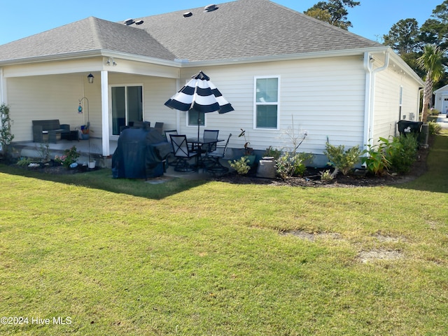 back of house with a patio area and a lawn