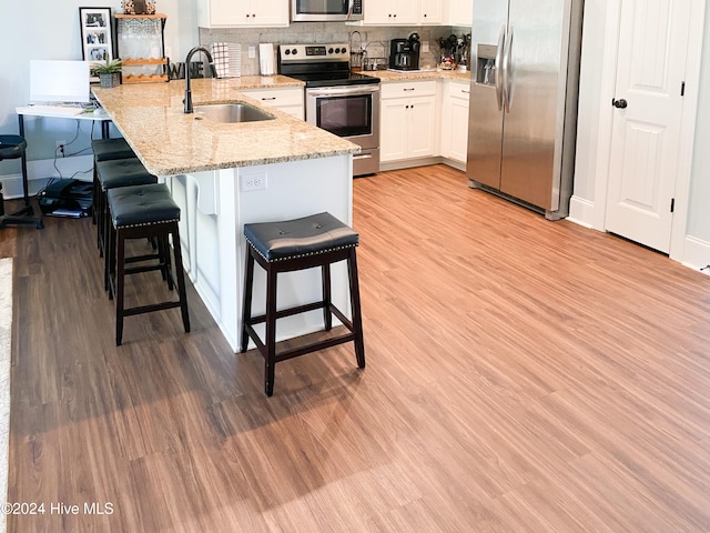 kitchen featuring white cabinetry, light wood-type flooring, kitchen peninsula, and appliances with stainless steel finishes