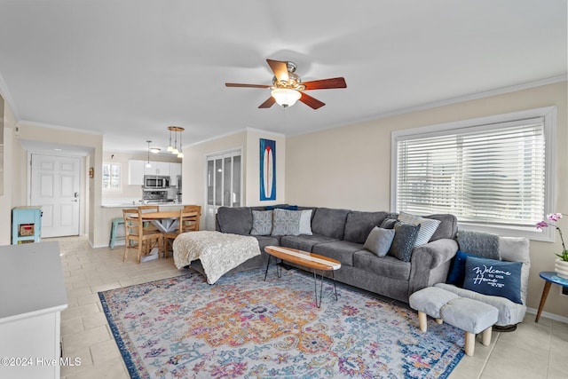 tiled living room with ornamental molding and ceiling fan