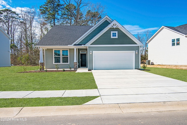 craftsman house with a front lawn and a garage